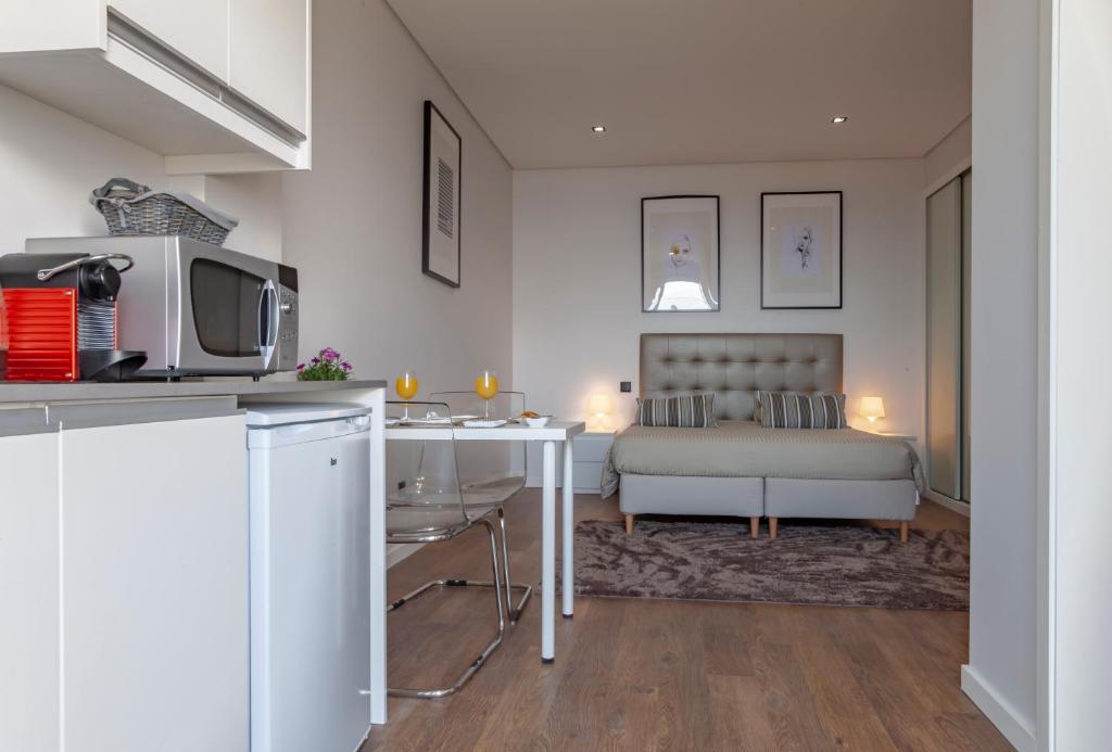 a kitchen and living room with a bed and a table at Infinito Azul in Caniço