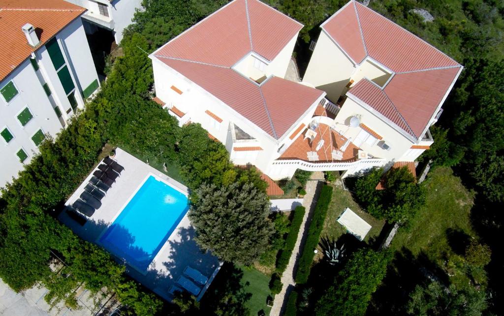 Cette chambre offre une vue sur une maison dotée d'une piscine. dans l'établissement Apartments Dvori Novalja, à Novalja