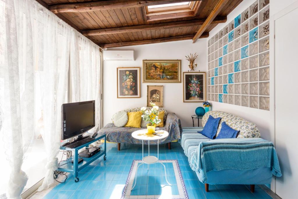 sala de estar con sofá y TV en Splendida Casa A Taormina " Casa di Anna ", en Taormina