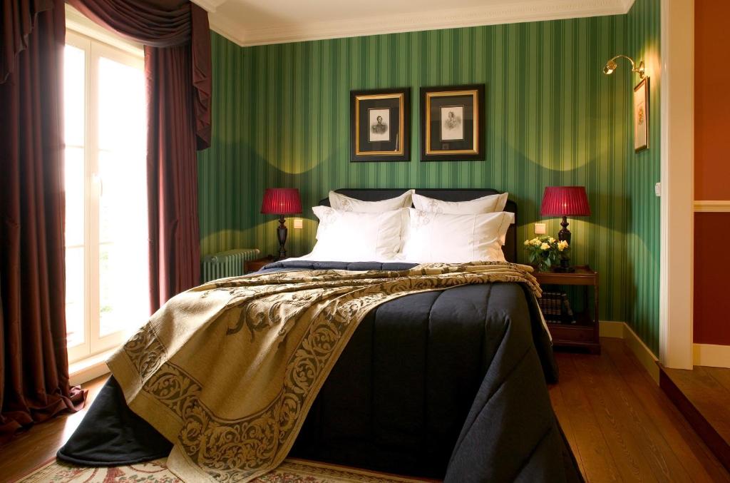 um quarto com paredes verdes e uma cama com almofadas brancas em Brugsche Suites - Luxury Guesthouse em Bruges