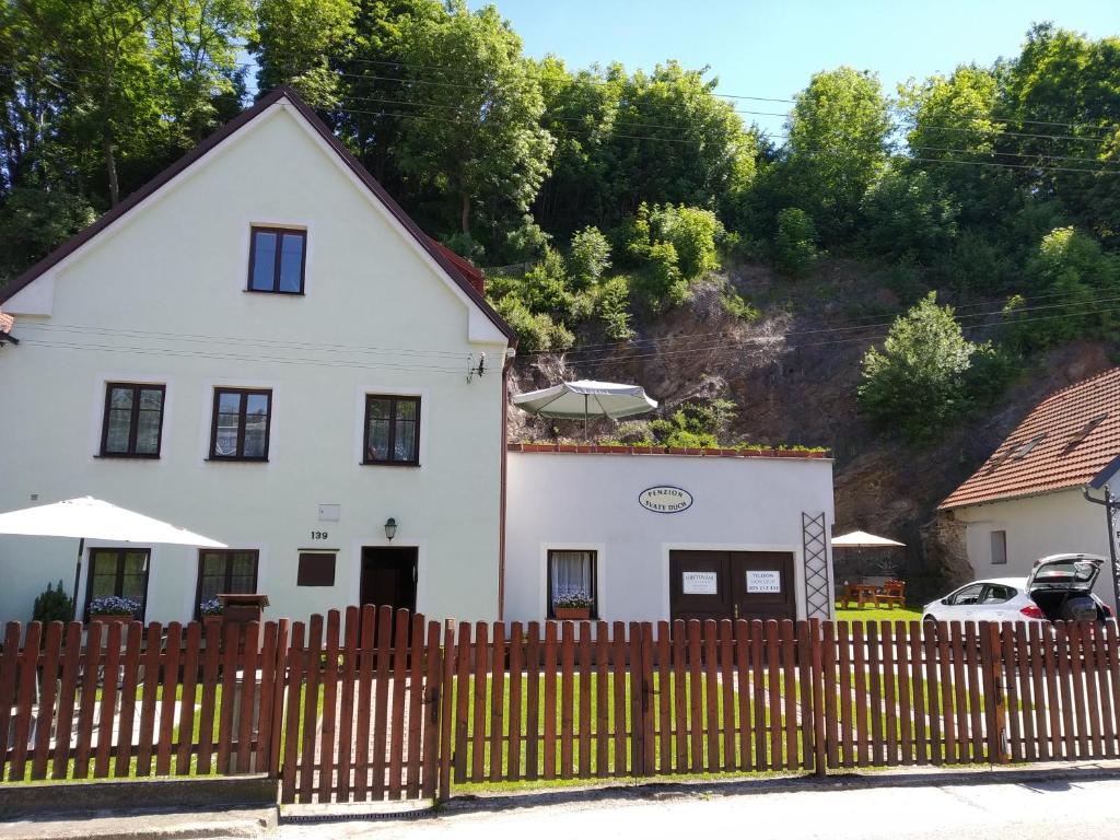 a white house with a fence in front of it at Penzion Sv. Duch in Český Krumlov