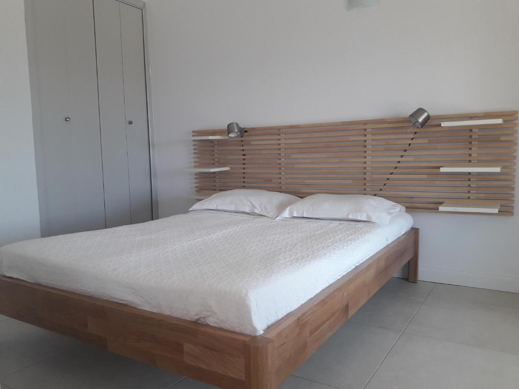 a bedroom with a large bed with a wooden headboard at I Casetti in Molini