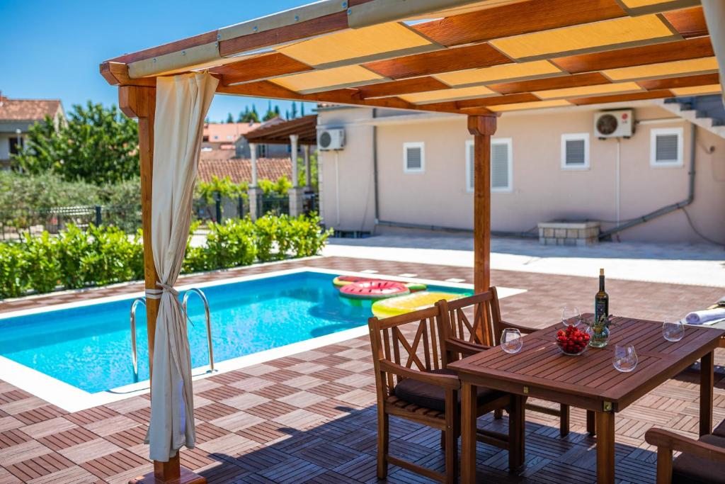 un patio con mesa y sillas junto a una piscina en Sunny House, en Korčula
