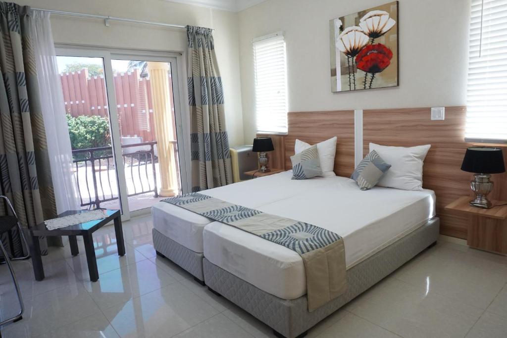 Un dormitorio con una cama grande y una ventana. en High-End finished apartment Higher Heights, Barbados, en Christ Church