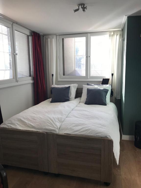 a large bed in a bedroom with two windows at B&B Trefkerk in Appelscha