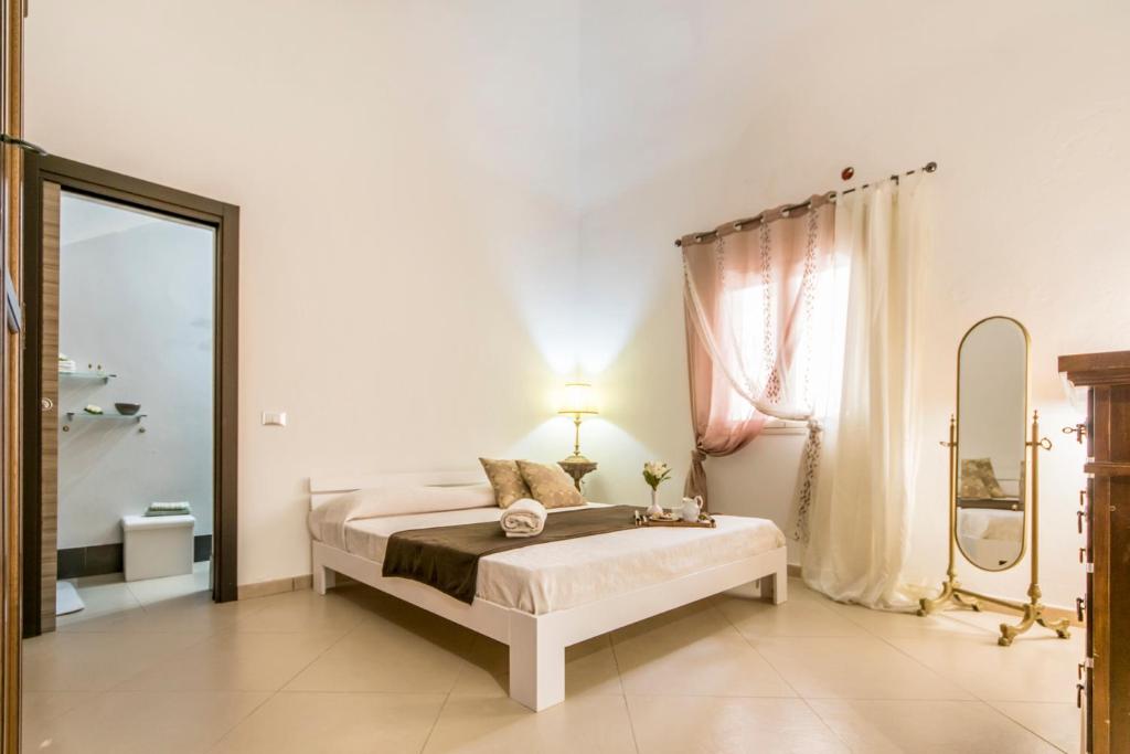 una camera bianca con letto e specchio di Casa marty a Mondello