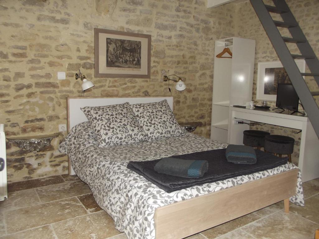 um quarto com uma cama num quarto com paredes de pedra em Chambre d´hote En Famille em Bayeux