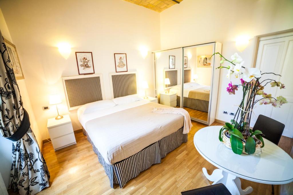 sypialnia z łóżkiem, stołem i lustrem w obiekcie Villa Paganini B&B w Rzymie