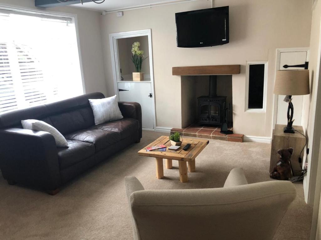 a living room with a couch and a coffee table at A quaint Wymondham cottage in Norwich