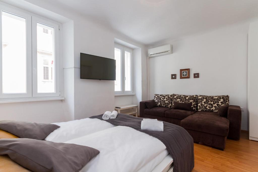 ein Wohnzimmer mit einem Bett und einem Sofa in der Unterkunft Apartment Petka in Piran