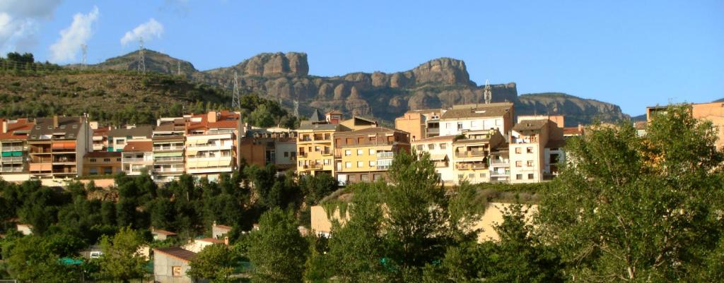 un grupo de edificios frente a una montaña en Apartaments Martí, en La Pobla de Segur