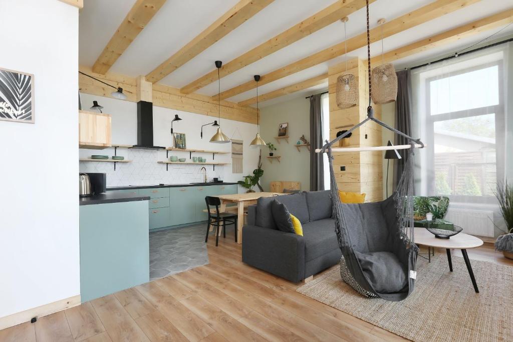 a living room with a couch and a kitchen at DOM NAD MORZEM PoDDĄBIE, TARAS WIDOKOWY ZE STREFĄ WYPOCZYNKU, SALA ZABAW in Poddąbie