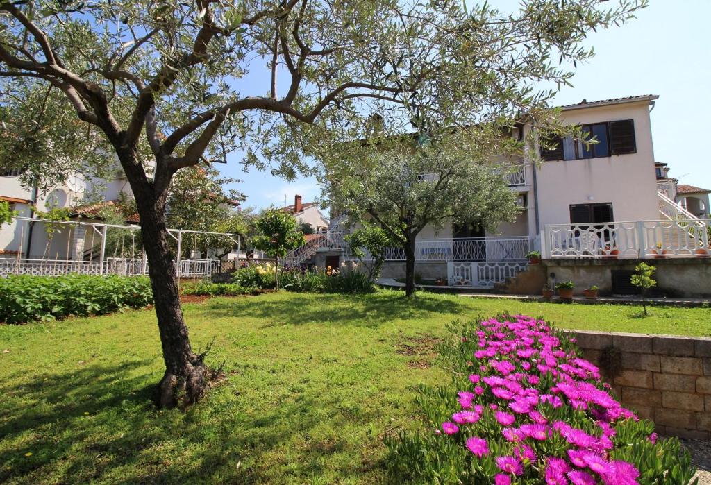 uma casa com flores cor-de-rosa num quintal em Apartment in Porec/Istrien 10030 em Porec