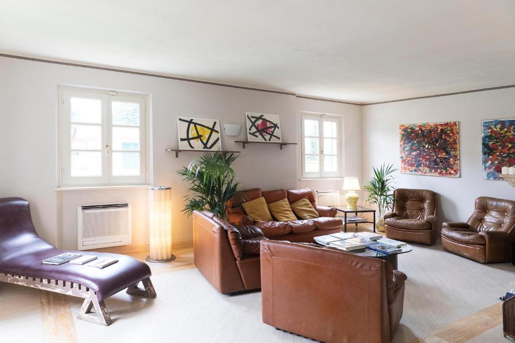 a living room with leather furniture and a fireplace at Relais Villa Isabel in Pietrasanta