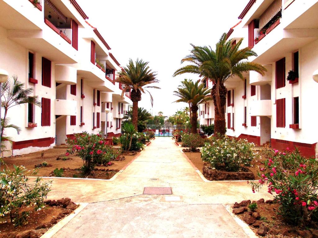 a courtyard of a building with palm trees and flowers at Apartment Altemar in Las Americas in Playa de las Americas