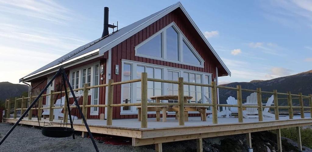 a red and white house with a table on a deck at Valberg High Quality Seaview Cabin in Valberg