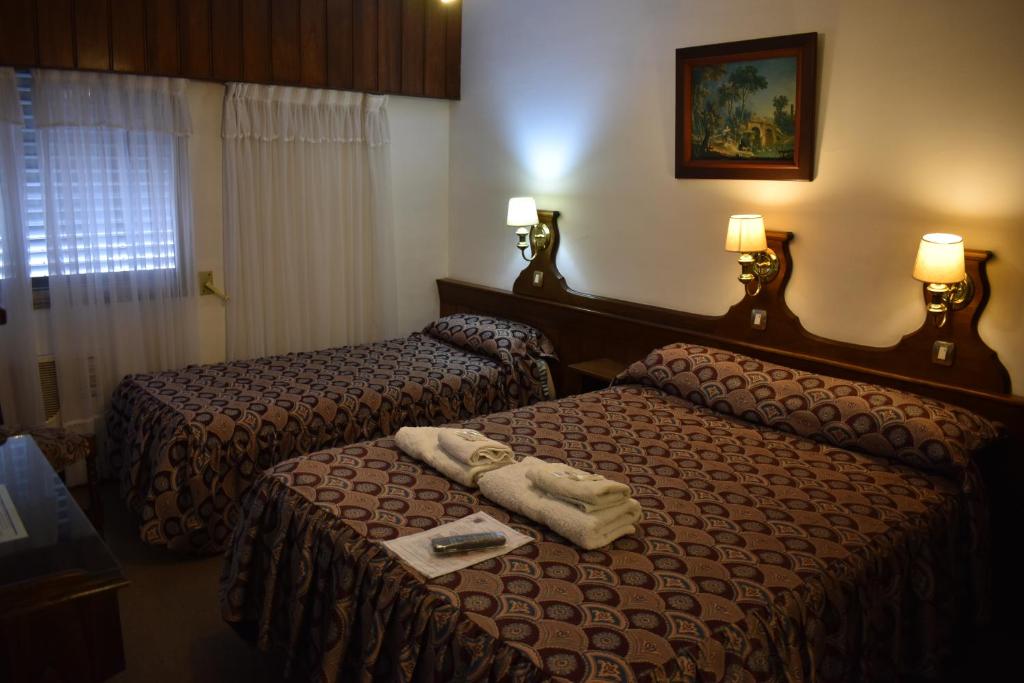 a hotel room with two beds with towels on them at Hotel Berlin in Gualeguaychú