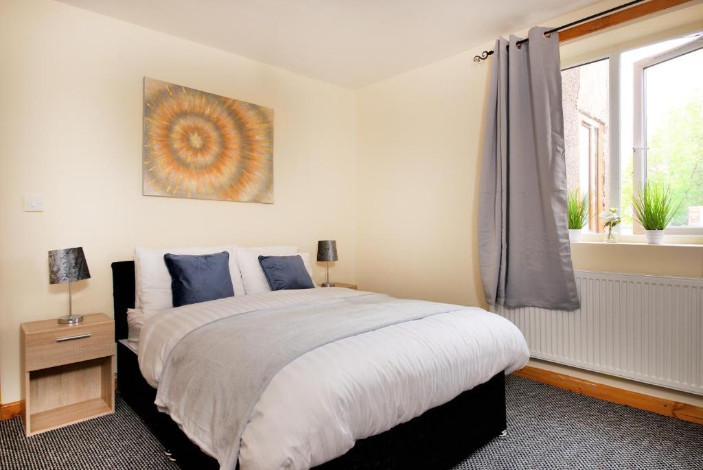 a bedroom with a large bed and a window at No 10 LimeHouse in Oldham