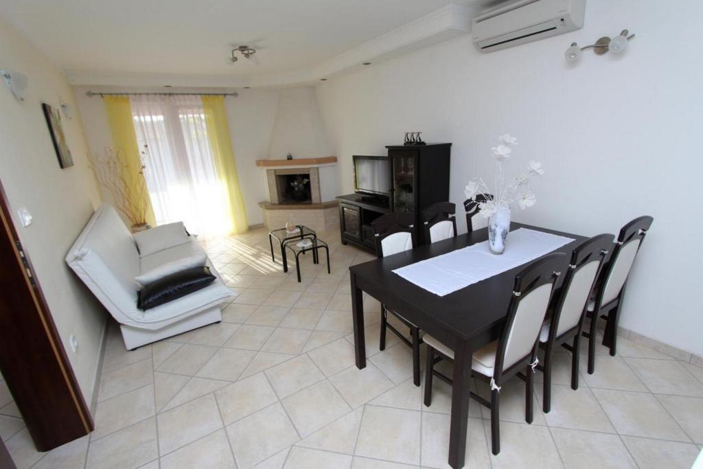 a dining room with a black table and chairs at Apartments Dujmović in Rovinj