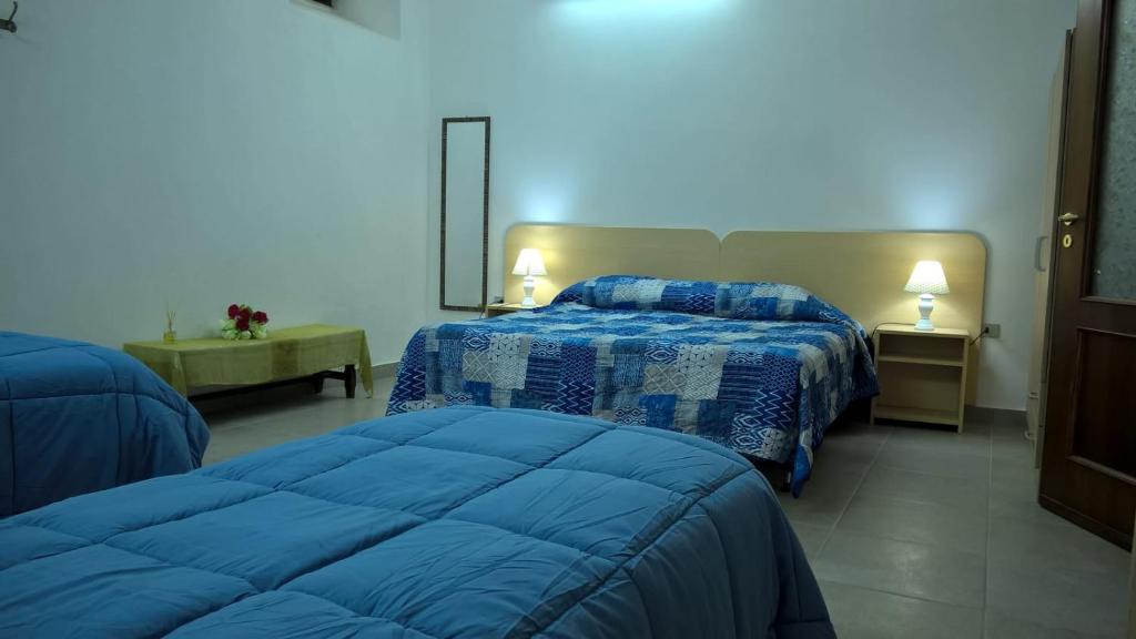 a bedroom with two beds in a blue room at Appartamento per Turisti Filoxenia in Santa Severina