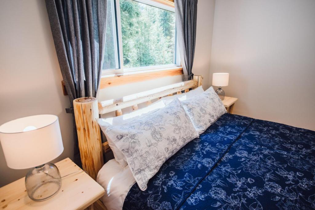 a bedroom with a blue bed with a window at Grizzly Paw B&B in Clearwater