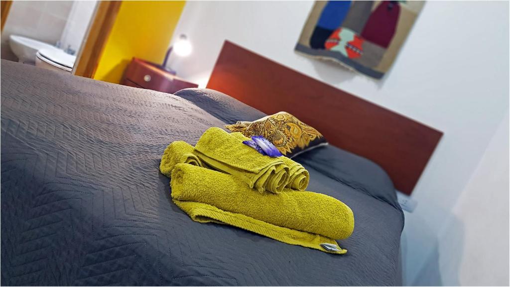 - une serviette jaune assise au-dessus du lit dans l'établissement Departamentos Segovia, à San Rafael
