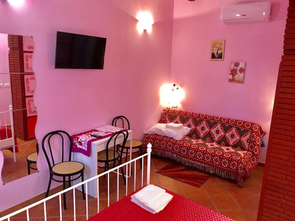 salon z czerwoną kanapą i stołem w obiekcie B&B Teodora w mieście Gaggi