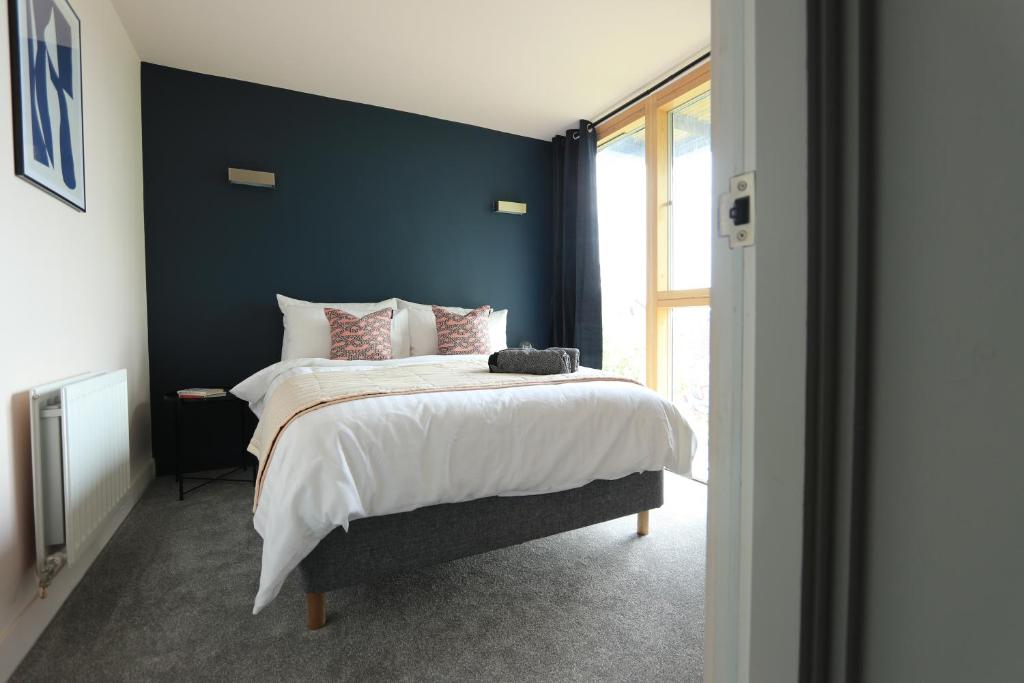 a bedroom with a large bed with a blue wall at Ecohome on the canal in a historic site near city in Coventry