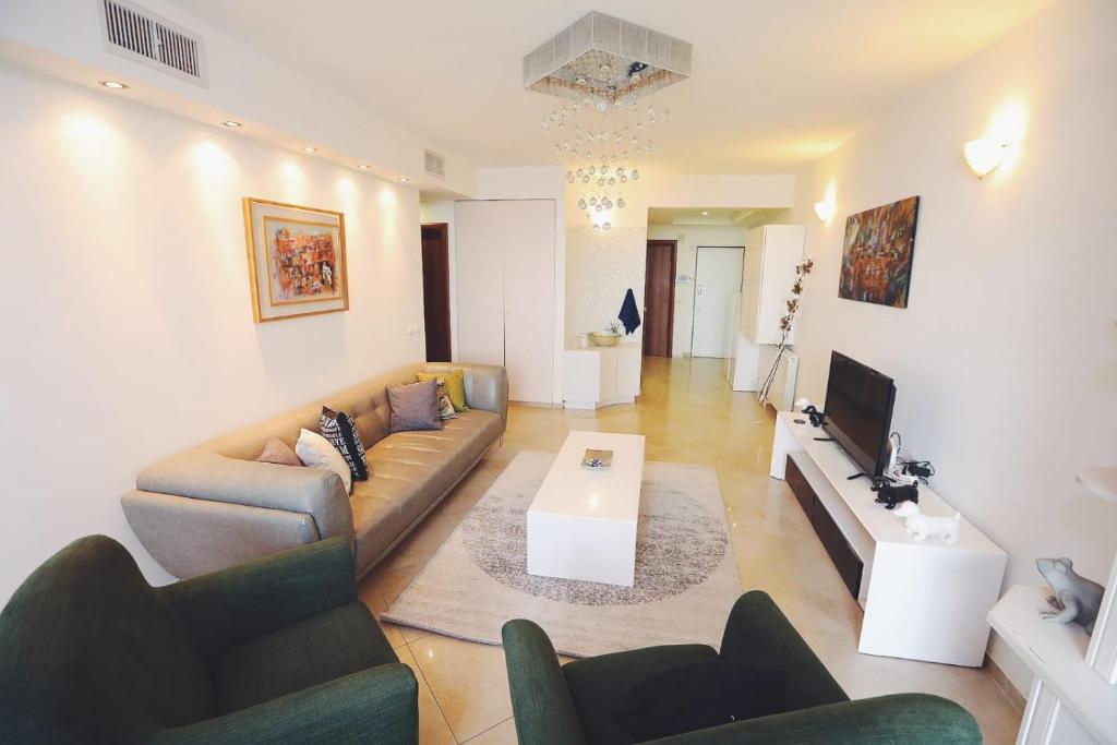sala de estar con sofá y mesa en Art Apartment In Mamila - Parking Best Location 2, en Jerusalén