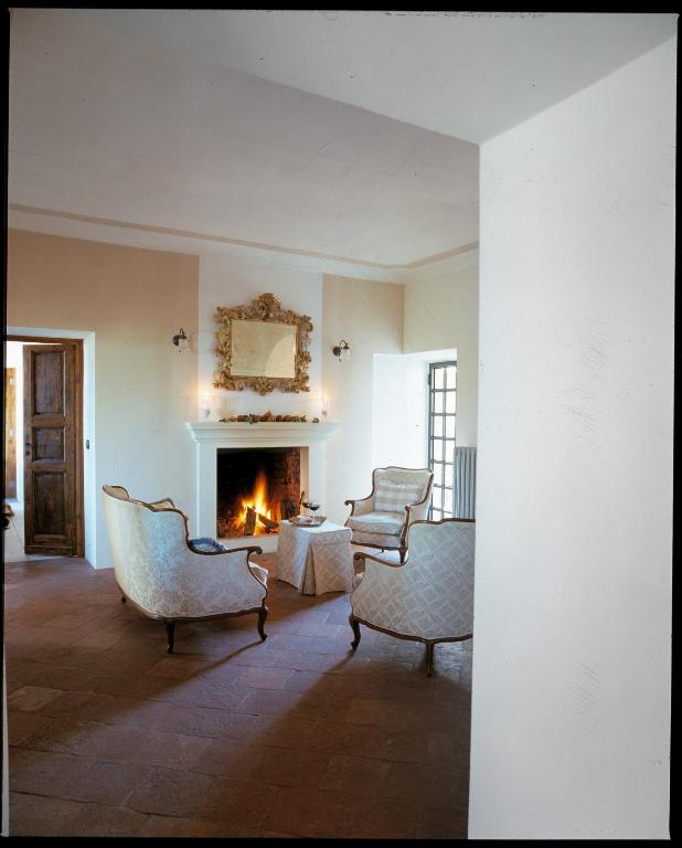 a living room with chairs and a fireplace at Dindina Agriturismo in Neviglie