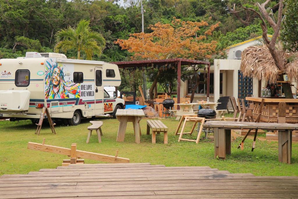 恩納村にある海が見えるCafe&Bar併設の宿のテントとピクニックテーブルの横に停めたRV