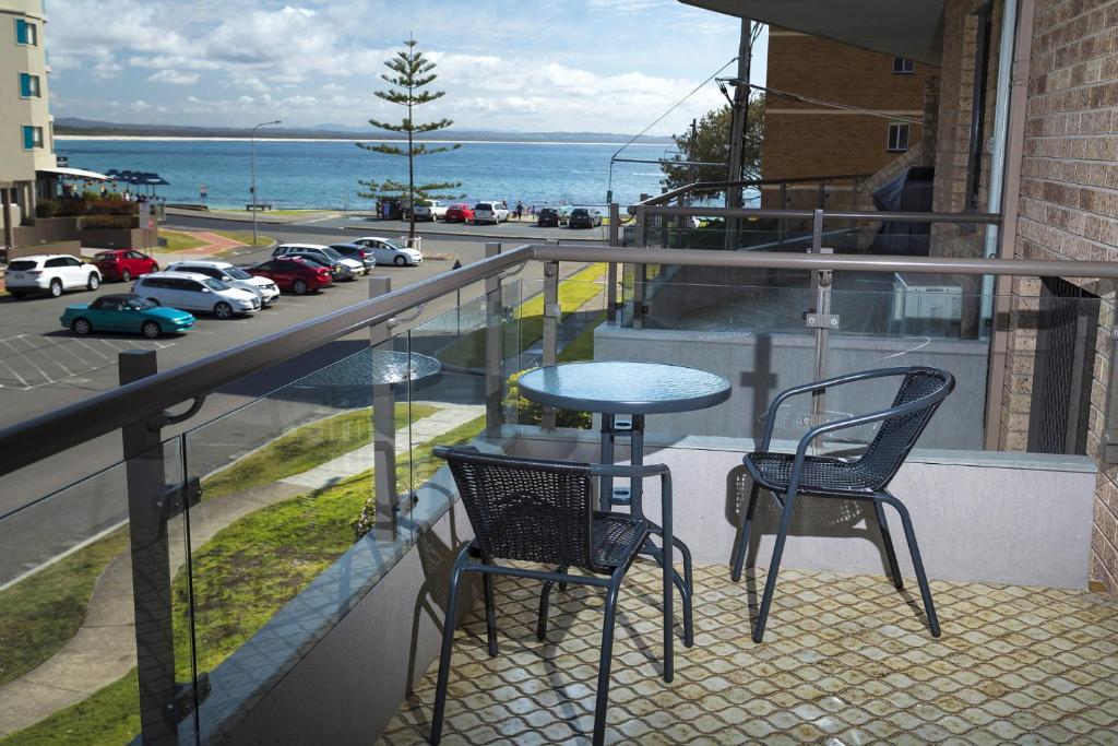 a balcony with two chairs and a table and a view of a street at Breakers 3 - linen not included in Forster