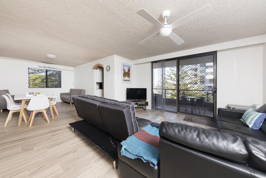 a living room with a black leather couch and a table at Breakers 3 - linen not included in Forster