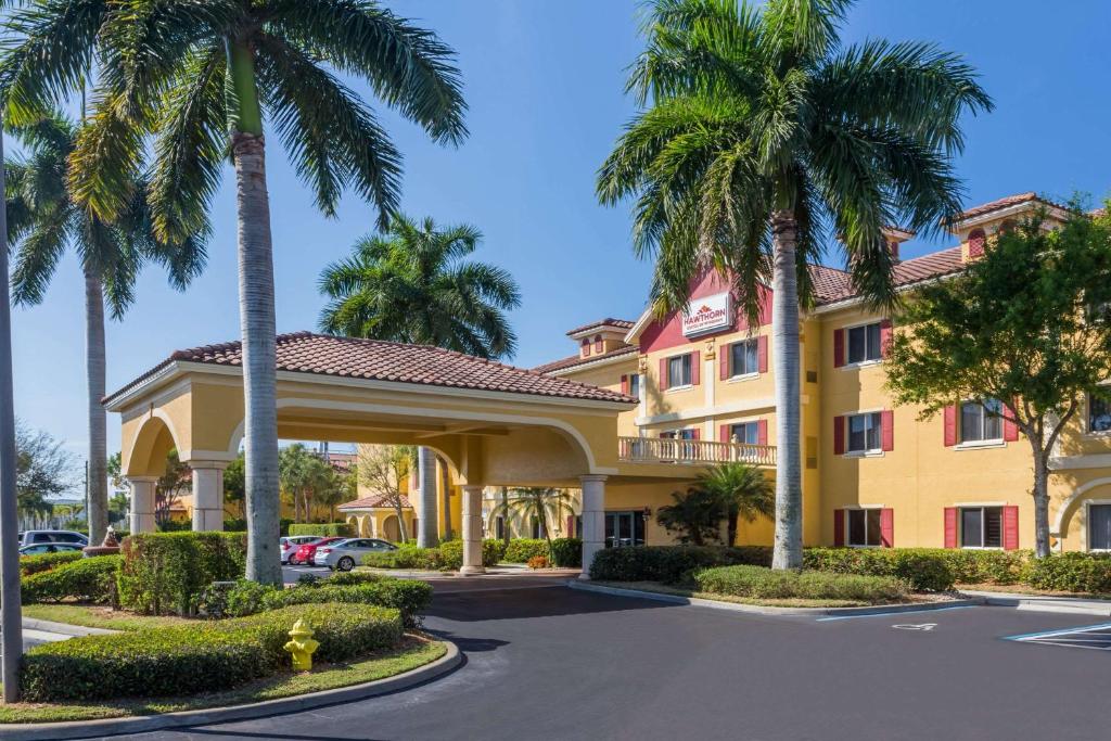 a hotel with palm trees in front of it at Hawthorn Suites by Wyndham Naples in Naples