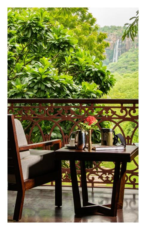 a table with flowers on top of a balcony at Fateh's Retreat, Homestay in Sawāi Mādhopur