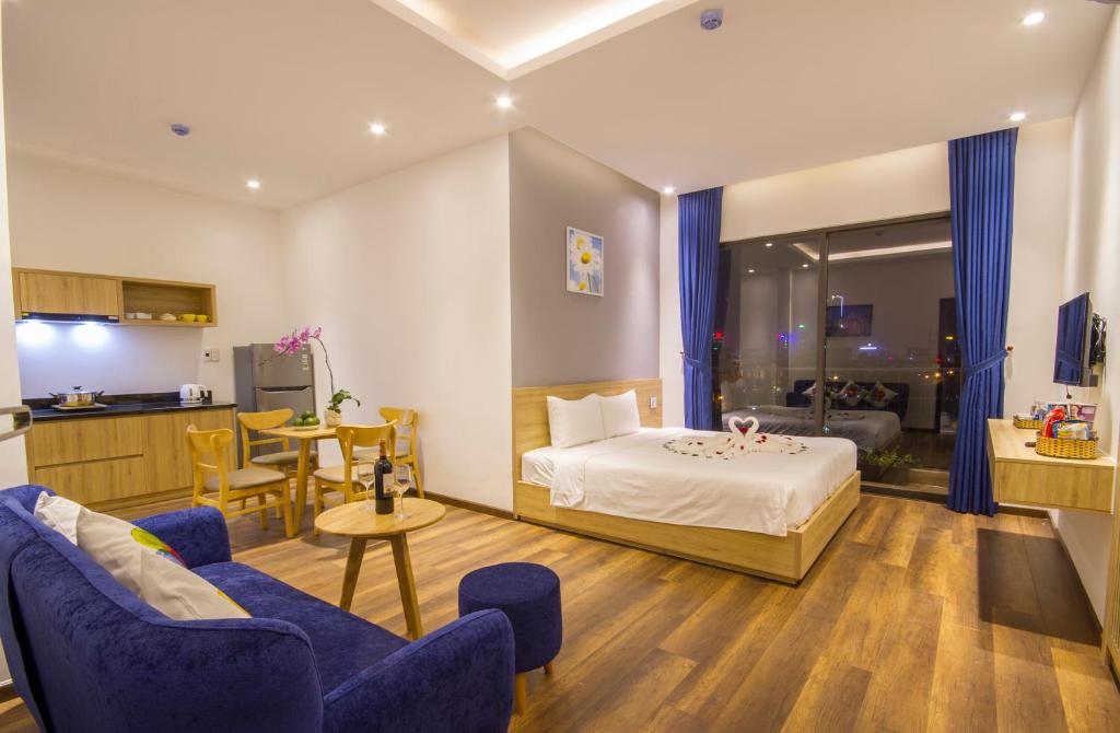 An open-plan suite with a kitchenette, living area, and double bed.