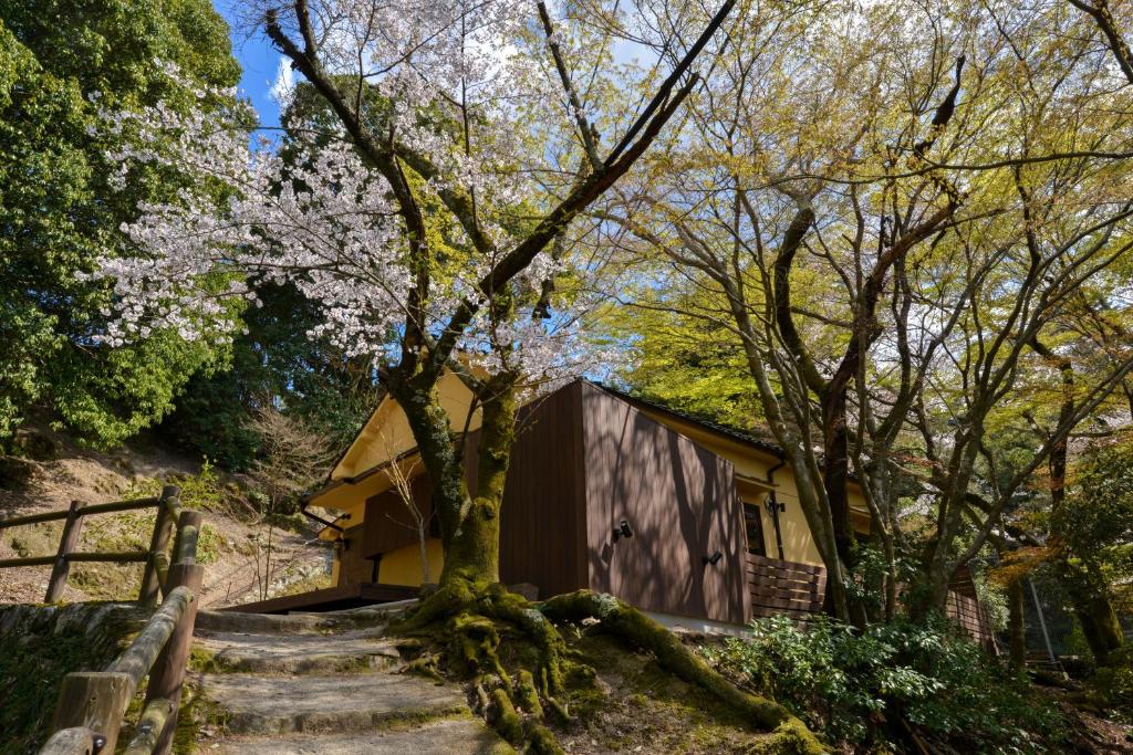 a tree in front of a building with stairs at Villa Hamorebi in Miyajima