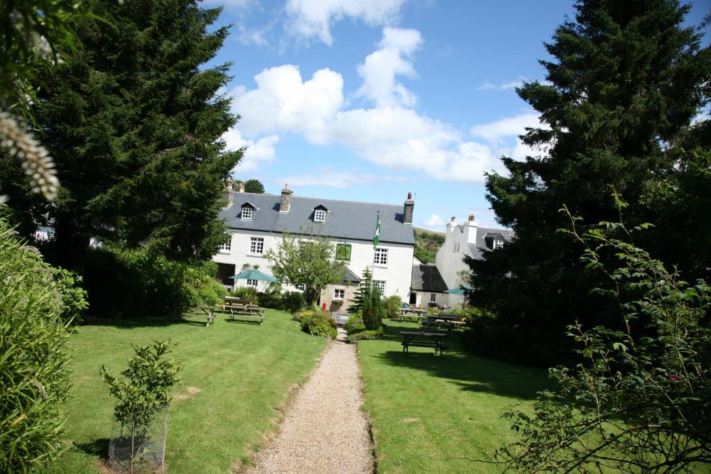 a large white house with a path in the yard at The Rock Inn in Bovey Tracey