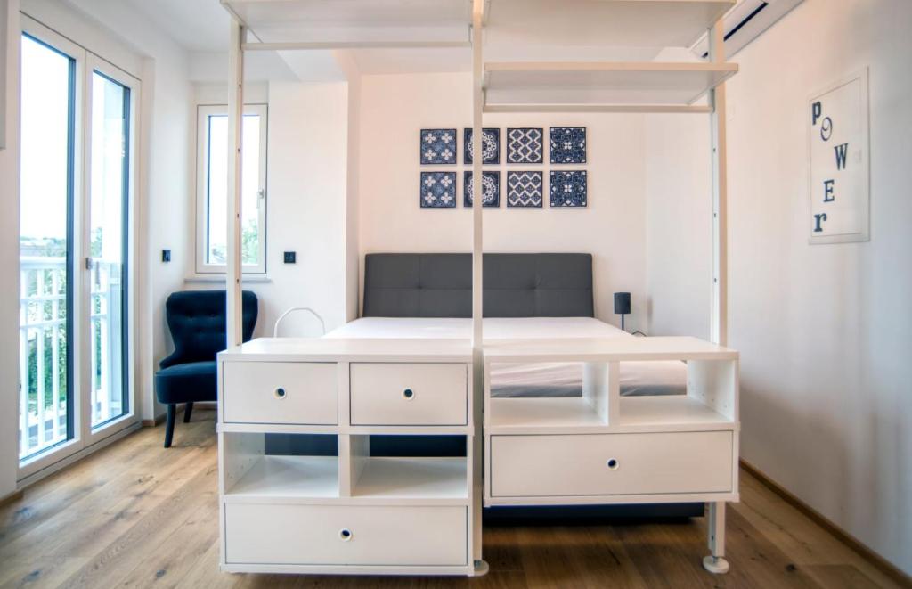 Schlafzimmer mit einem weißen Bett und einem Schreibtisch in der Unterkunft SPA Boutique Appartement # 26 with Indoor- and Outdoorpool in Neusiedl am See