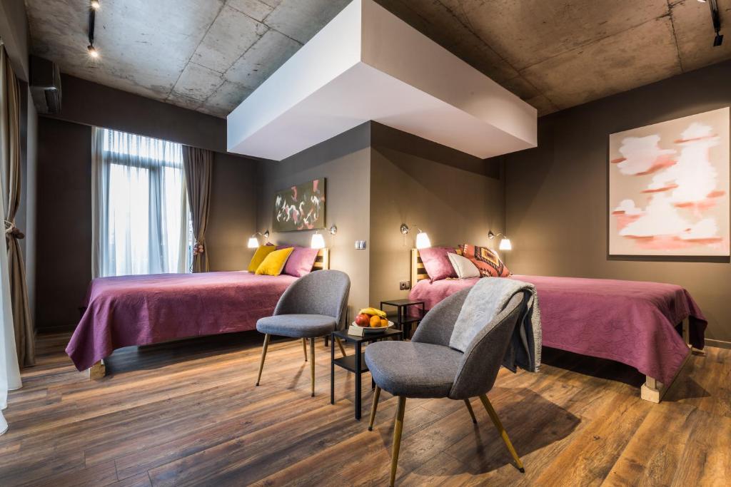 a bedroom with two beds and a table and chairs at PraDo Rooms in Tbilisi City