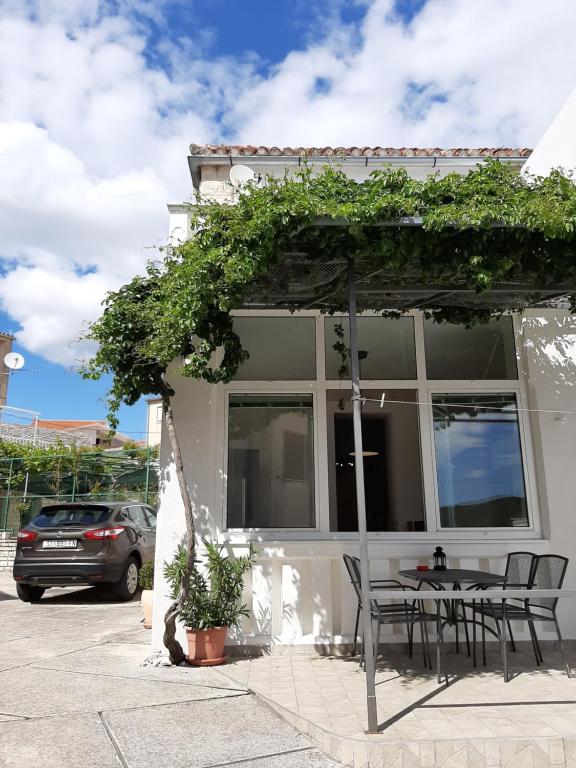 une table et des chaises devant une maison dans l'établissement Apartments La Mare, à Primošten