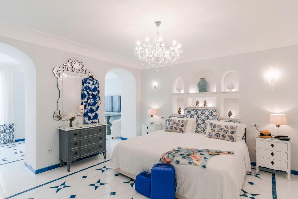 a room with a bed, a dresser, a lamp, and a at Hotel Villa Maria in Ravello