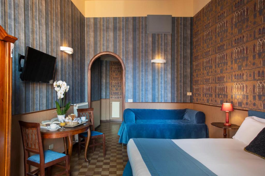 a hotel room with a bed and a blue couch at Welcome House in Rome