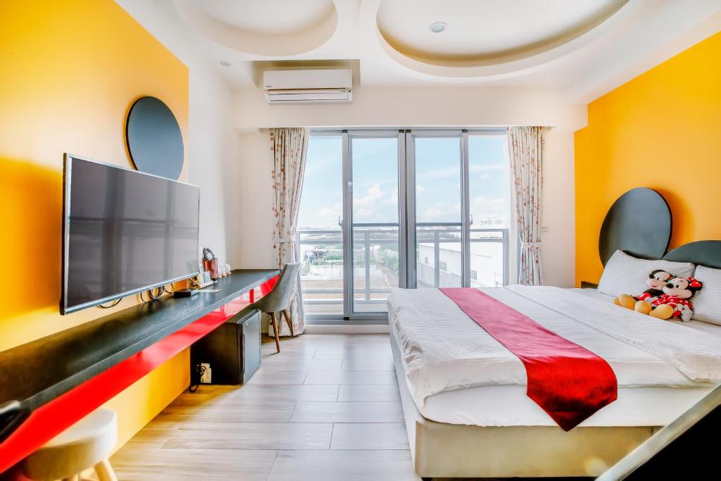 1 dormitorio con 1 cama grande y TV de pantalla plana en Party of the Ocean B&B, en Magong