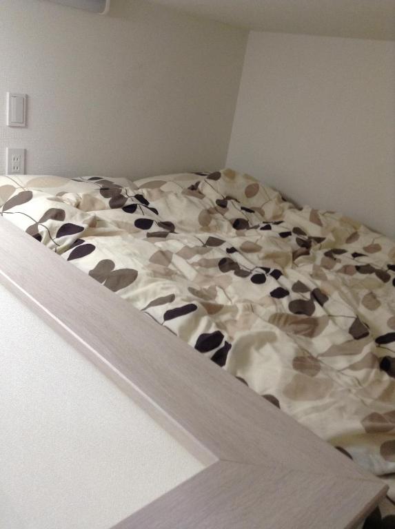 1 cama no hecha en una esquina de un dormitorio en Shitamachi Base en Tokio