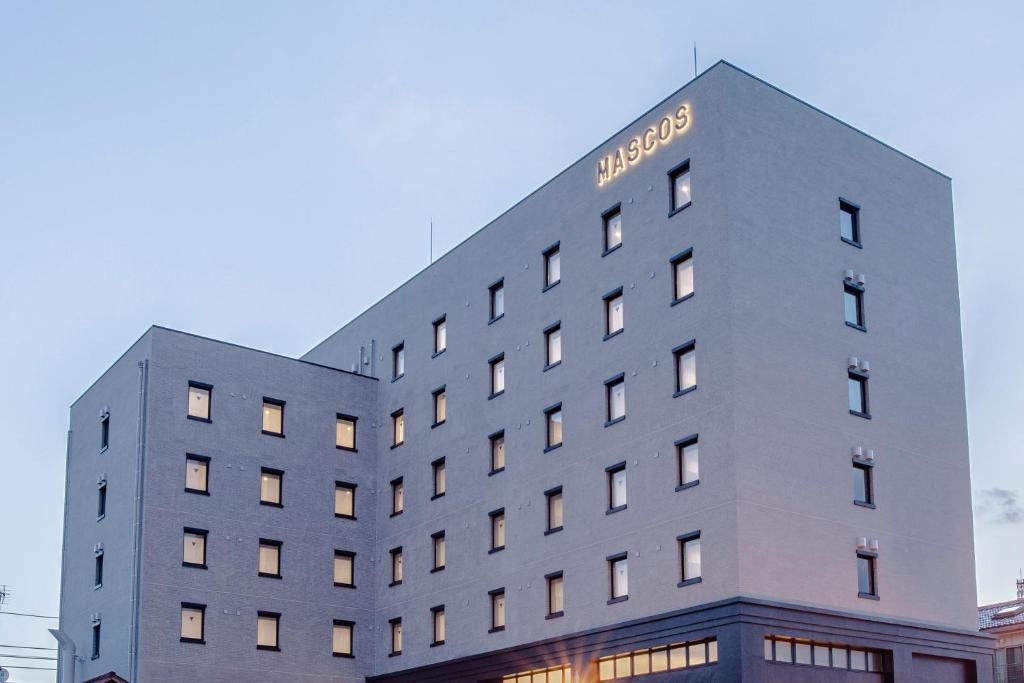 un edificio con un cartello sul lato di MASCOS HOTEL Masuda Onsen a Masuda