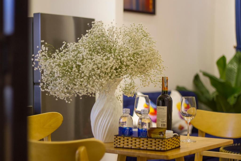 A styled dining table set with wine, water and a large vase of flowers.