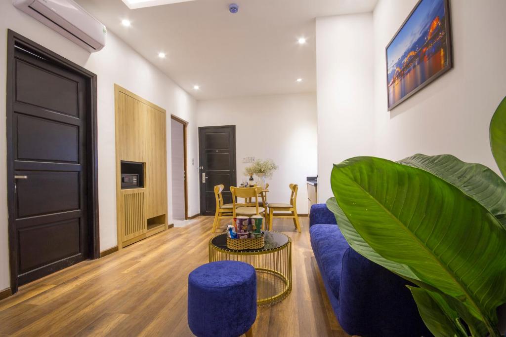 A compact sitting room has a blue sofa, dining table, television, and built-in storage.