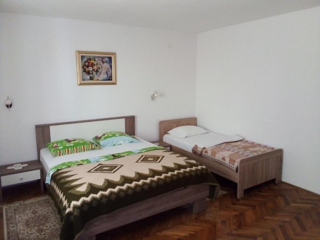 two beds sitting next to each other in a room at Filipo Apartments in Poreč