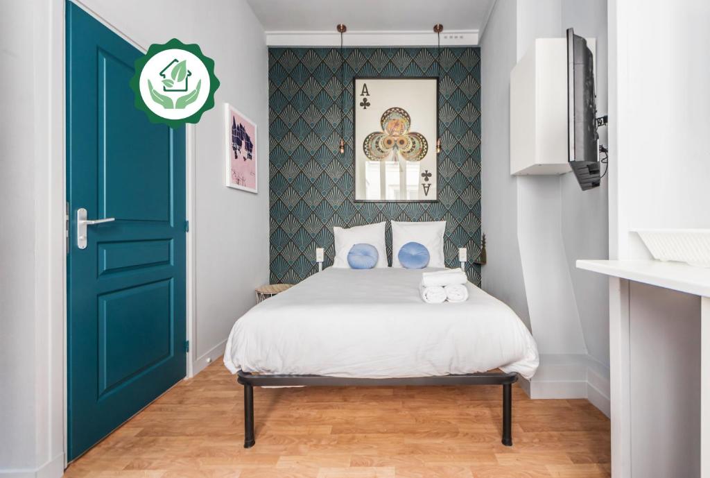 une chambre avec un lit et une porte verte dans l'établissement WS Saint-Lazare - Opera, à Paris